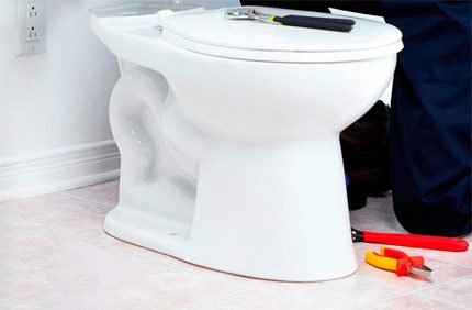 Een toilet plaatsen op een tegelvloer