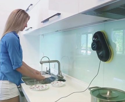 Ang Robot ay naghugas ng isang gumaganang apron sa kusina