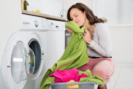 Vrouw neemt wasgoed uit de wasmachine