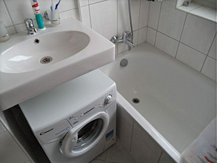 White hinged sink over the washing machine