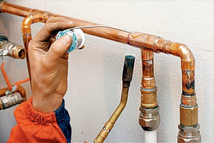 Meester soldeer een koperen pijp met soldeer