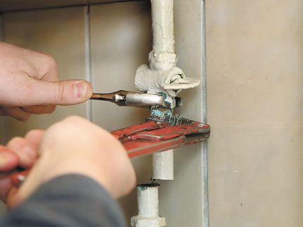 De meester schroeft de gasleiding los