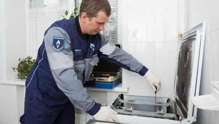 De meester sluit de gaskachel aan